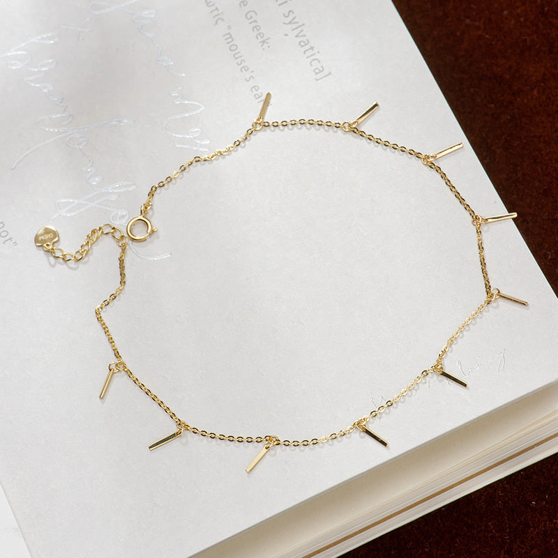 Einfache und farblose kleine streifenfarbige goldene Fußkette