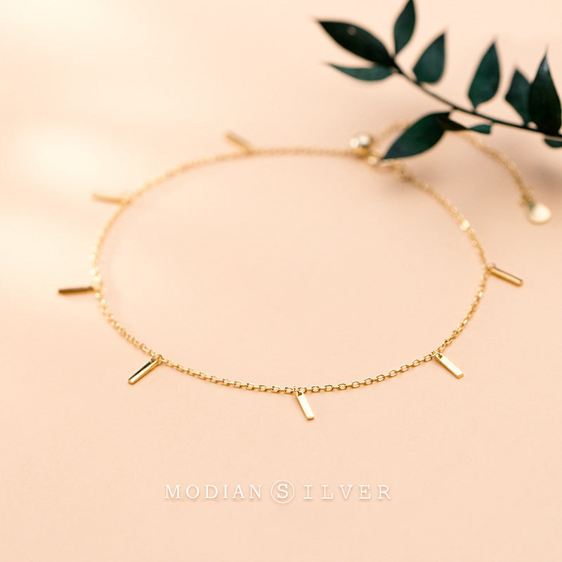 Einfache und farblose kleine streifenfarbige goldene Fußkette