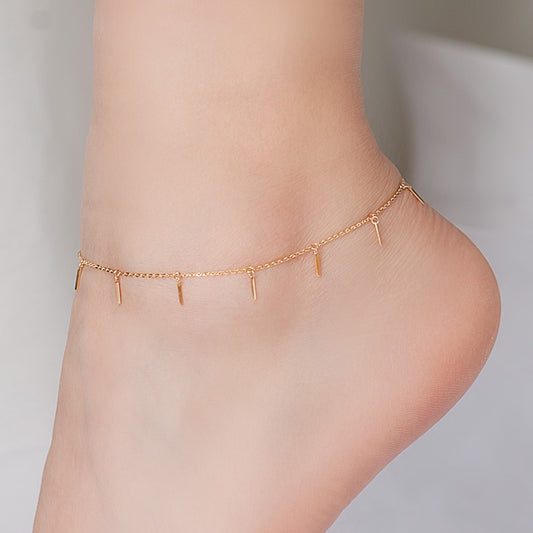Einfache und farblose kleine streifenfarbige goldene Fußkette